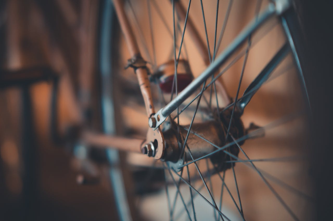 Detailed close-up of a vintage bicycle wheel showcasing rusty spokes and classic design elements.